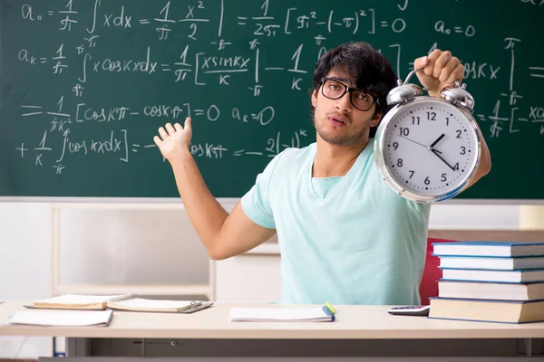 Joven matemático estudiante masculino frente a pizarra — Foto de Stock