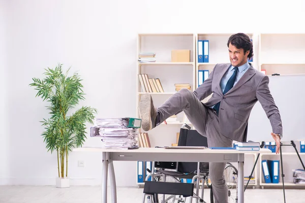 Young handsome employee in wheelchair at the office — Stock Photo, Image