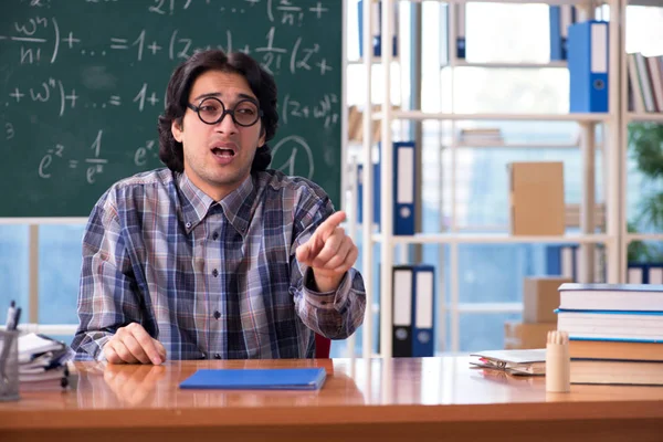 Young funny math teacher in front of chalkboard — Stock Photo, Image