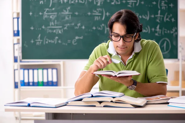 Knappe student voorkant schoolbord met formules — Stockfoto