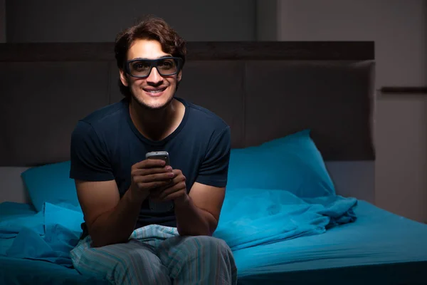 Hombre viendo la televisión por la noche en la cama —  Fotos de Stock