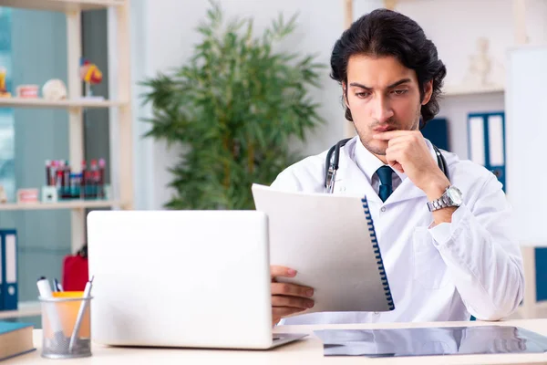 Joven médico guapo que trabaja en la clínica —  Fotos de Stock