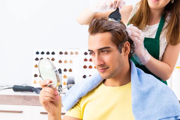 Cabeleireiro mulher aplicando tintura para o cabelo do homem — Fotografia de Stock