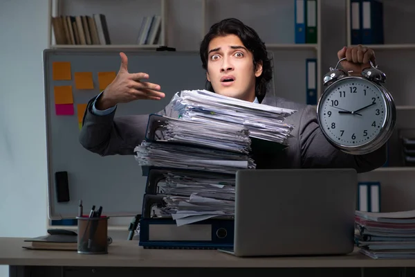 Young male employee working late at office