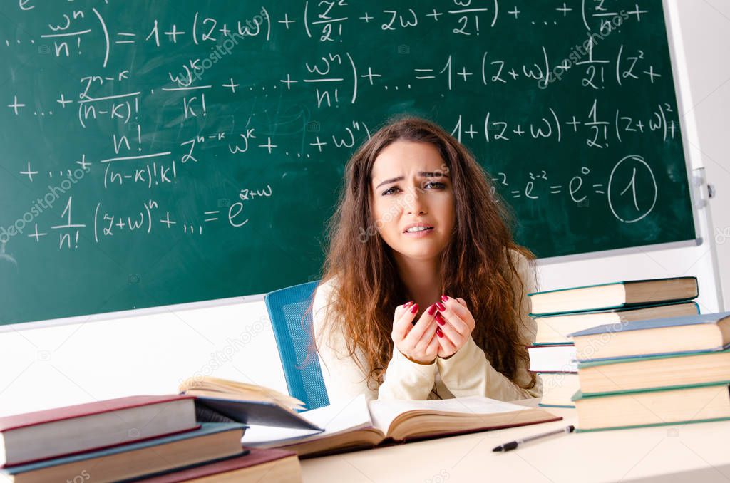 Young female math teacher in front of chalkboard