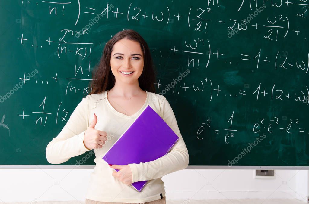 Young female math teacher in front of chalkboard