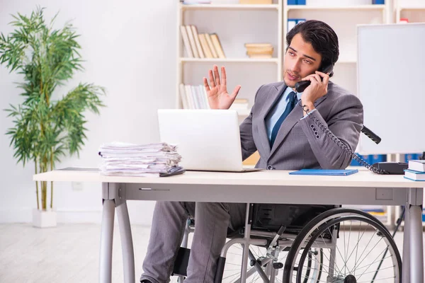 Junge hübsche Angestellte im Rollstuhl im Büro — Stockfoto