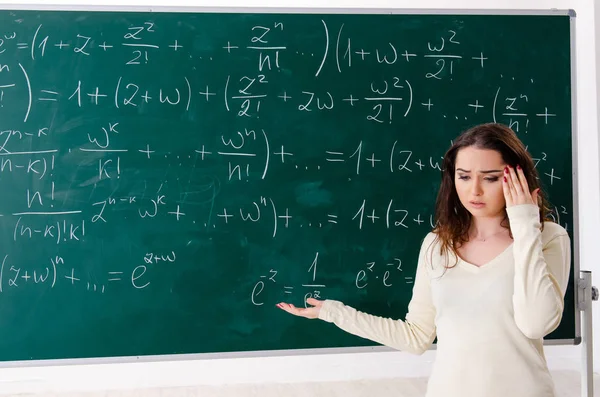 Joven profesora de matemáticas delante de pizarra — Foto de Stock