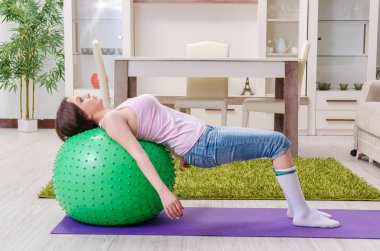 Genç güzel kadın evde egzersizleri yapıyor 