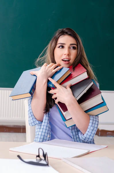 Female student in front of chalkboard — Stock Photo, Image