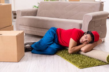 İçeride çalışan kutularla çalışan genç bir erkek müteahhit. 