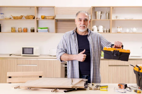 Contratista de edad reparador que trabaja en la cocina — Foto de Stock