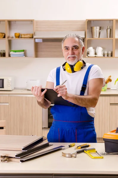 Aged contractor repairman working in the kitchen — Stock Photo, Image