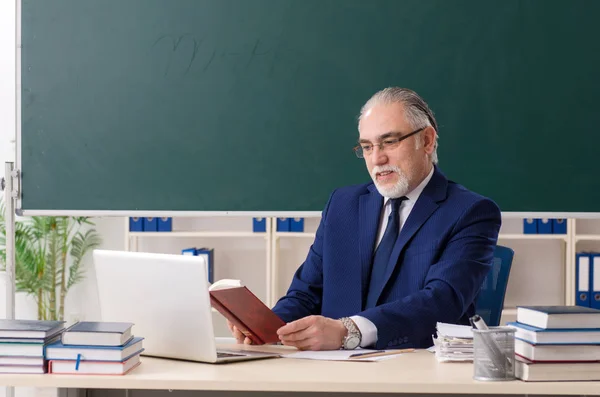 Leeftijd mannelijke leraar in de voorkant van schoolbord — Stockfoto