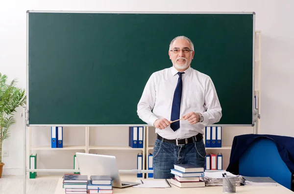 Leeftijd mannelijke leraar in de voorkant van schoolbord — Stockfoto