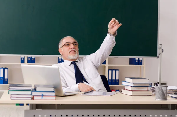 Leeftijd mannelijke leraar in de voorkant van schoolbord — Stockfoto