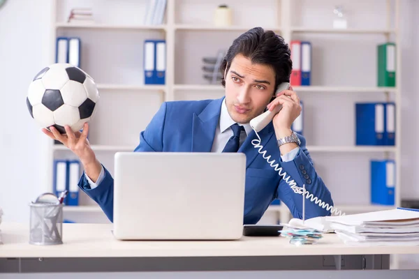 Junger gutaussehender Geschäftsmann mit Fußball im Büro — Stockfoto