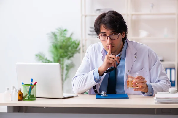 Joven doctor bebiendo en el consultorio —  Fotos de Stock