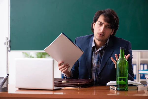 Male teacher drinking in the classroom — Stock Photo, Image