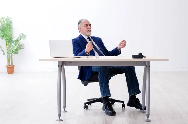 Homme d'affaires âgé faisant des exercices de yoga dans le bureau — Photo