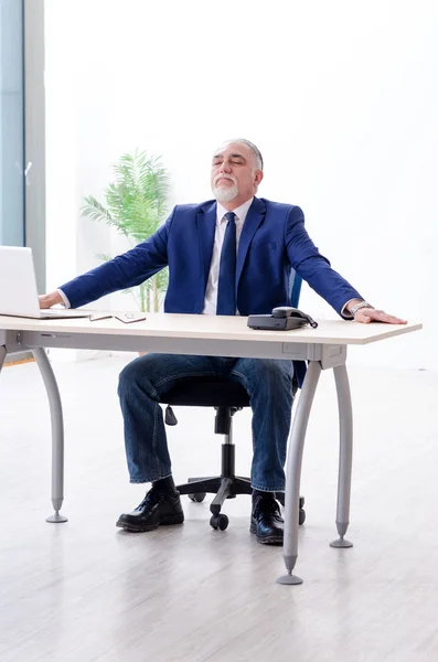 Betagter Geschäftsmann macht Yoga-Übungen im Büro — Stockfoto