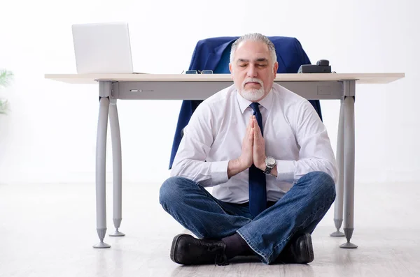 Éves üzletember csinál jóga gyakorlatok az irodában — Stock Fotó