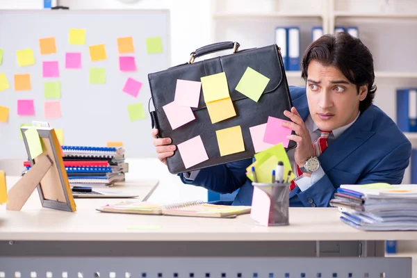 Young male handsome employee in conflicting priorities concept — Stock Photo, Image
