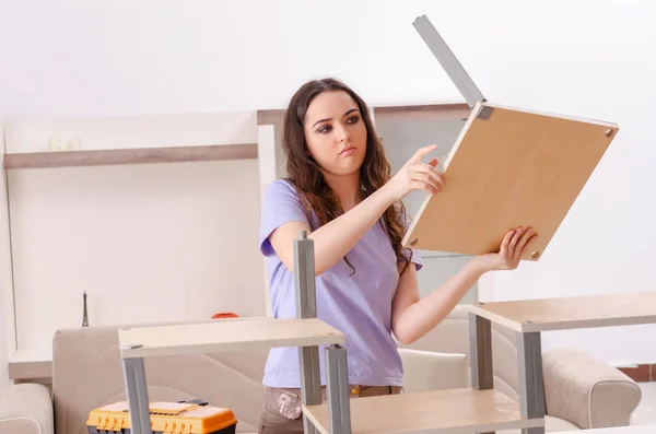 Jonge vrouw repareert stoel thuis — Stockfoto