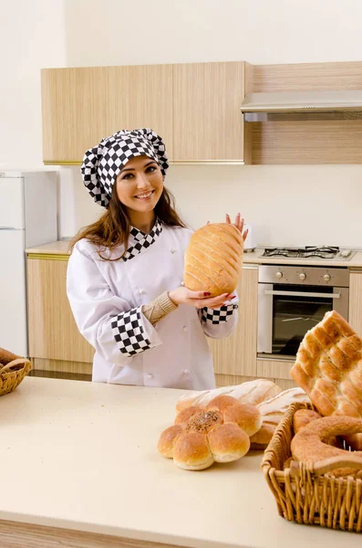 Young female baker working in kitchen