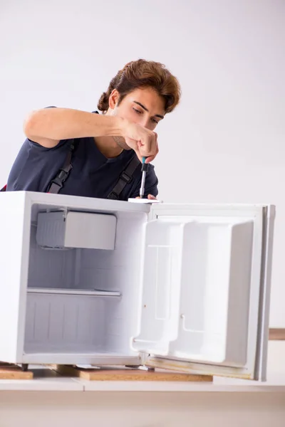 Genç yakışıklı yüklenici tamir buzdolabı — Stok fotoğraf