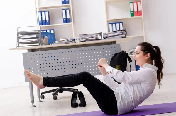 Жінка-працівник робить спортивні вправи в офісі — стокове фото