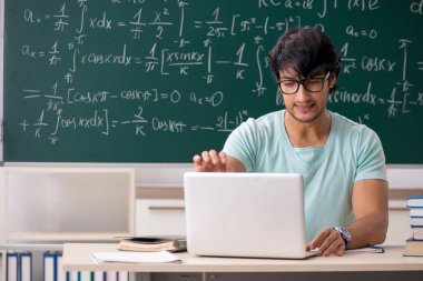 Kara tahta önünde genç erkek öğrenci matematikçi 