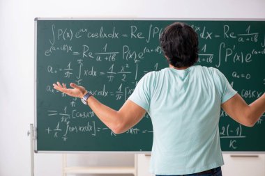 Kara tahta önünde genç erkek öğrenci matematikçi 