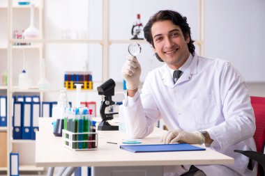 Laboratuvarda çalışan yakışıklı bir kimyager. 