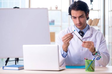 Beyaz tahta önünde genç yakışıklı Doktor 