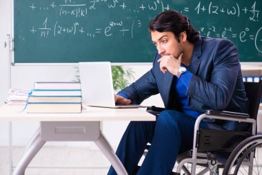 Yakışıklı delikanlı kara tahta önünde tekerlekli sandalyede 