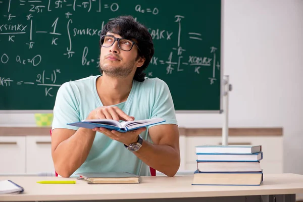 Mladý muž student matematik před tabuli — Stock fotografie