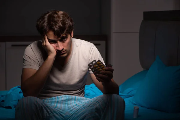Sick man in his bed with medicines — Stock Photo, Image