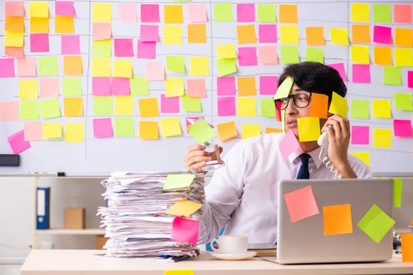 Young employee in conflicting priorities concept — Stock Photo, Image