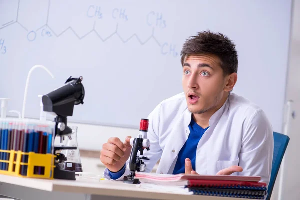 Jovem químico sentado no laboratório — Fotografia de Stock