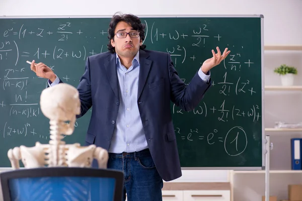 Молодий вчитель математики та студентський скелет — стокове фото