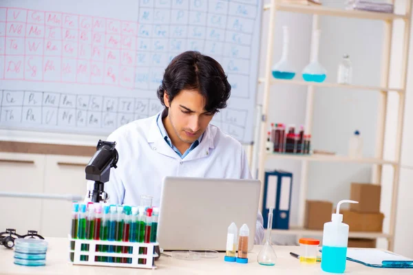 Молодой химик работает в лаборатории — стоковое фото