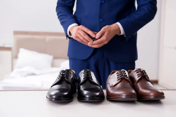 Young handsome businessman choosing shoes at home — Stock Photo, Image