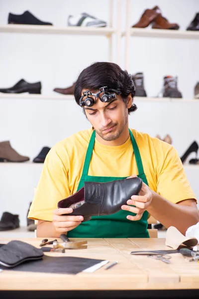 Joven reparando zapatos en taller — Foto de Stock