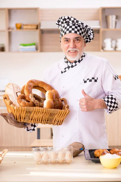 Viejo panadero trabajando en la cocina — Foto de Stock