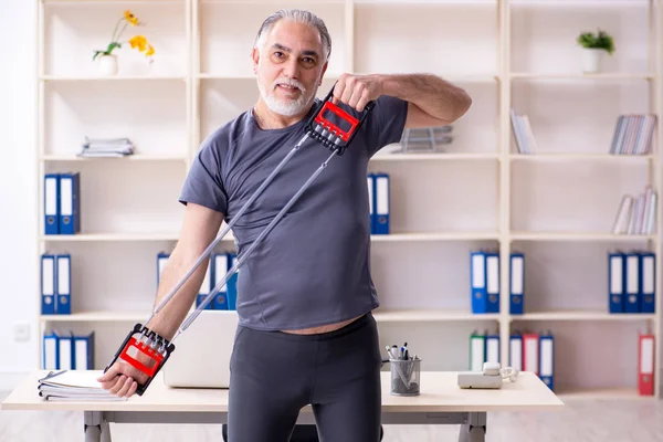 Witte baard oude man werknemer doen oefeningen in het kantoor — Stockfoto