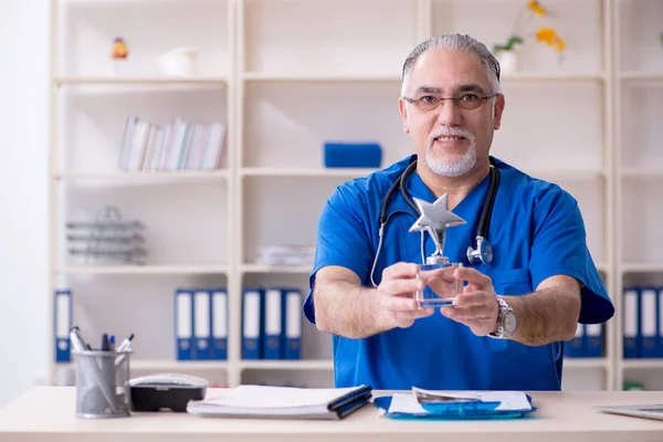 Weißbärtiger alter Arzt arbeitet in Klinik — Stockfoto