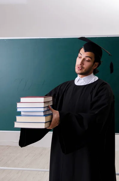 Étudiant diplômé devant le tableau vert — Photo