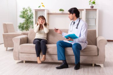 Genç, yakışıklı doktor, kadın hastayı evinde ziyaret ediyor. 