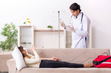 Genç, yakışıklı doktor, kadın hastayı evinde ziyaret ediyor. 